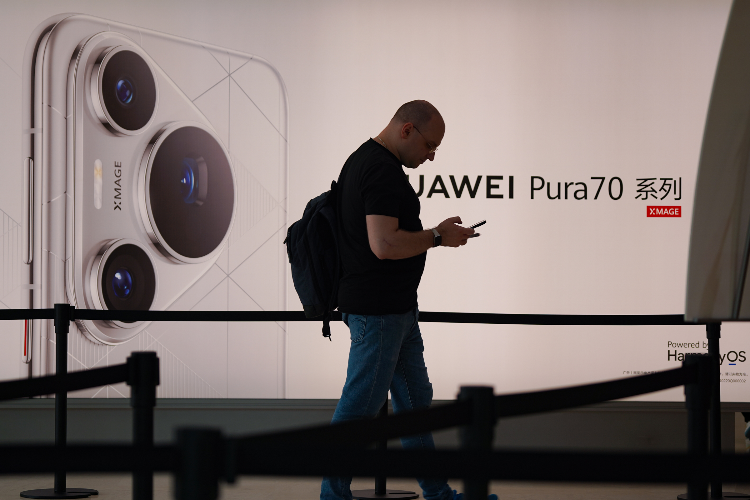 Một người đi ngang biển hiệu Huawei Pura 70 tại cửa hàng Huawei ở Thâm Quyến, Trung Quốc, tháng 4/2024. Ảnh: Lưu Quý