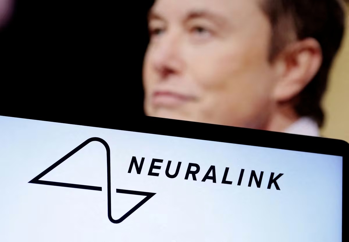 Logo Neuralink hiển thị trên một chiếc laptop, đằng sau là hình ảnh của Musk. Ảnh:Reuters