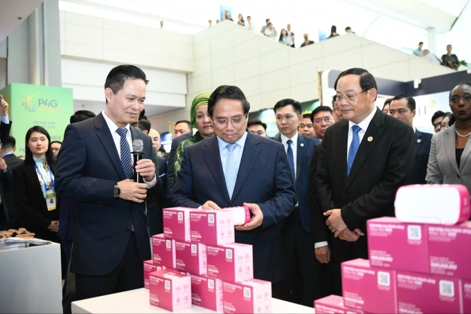 Thủ tướng Phạm Minh Chính xem một chiếc loa báo chuyển khoản tại gian hàng của MoMo trong sự kiện P4G 2025. Ảnh: Lưu Quý