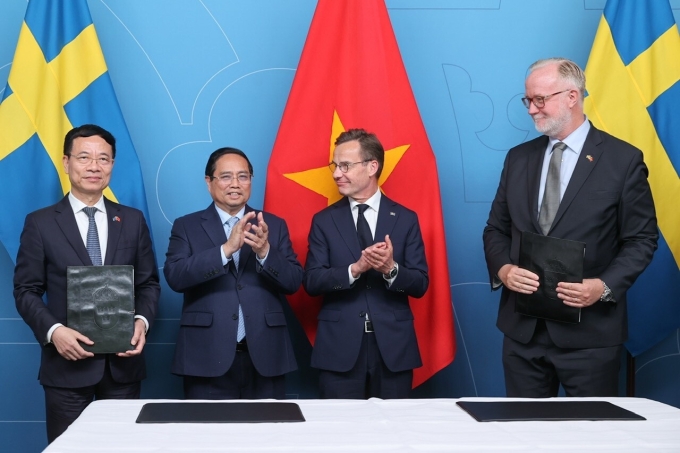 Bộ trưởng Nguyễn Mạnh Hùng (trái) và Bộ trưởng Giáo dục và Nghiên cứu Thụy Điển Johan Pehrson (phải) trao Thỏa thuận hợp tác. Ảnh: Nhật Bắc