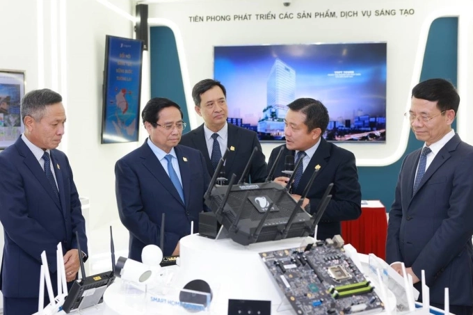 Thủ tướng (người thứ hai bên trái) và Bộ trưởng Nguyễn Mạnh Hùng (người ngoài cùng bên phải) thăm gian trưng bày bộ định tuyến WiFi 7 do VNPT phát triển. Ảnh: Thúy Quỳnh