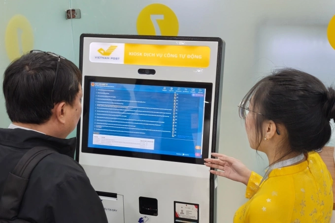 Người dân được hướng dẫn sử dụng kiosk tự phục vụ tại bộ phận một cửa của Bộ Khoa học và Công nghệ. Ảnh: Trọng Đạt