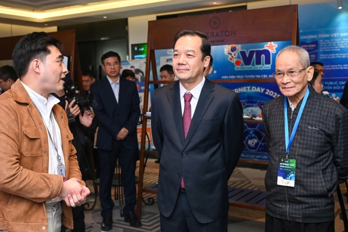 Thứ trưởng Phạm Đức Long (đứng giữa) và nguyên Thứ trưởng Thường trực Bộ Bưu chính Viễn thông Mai Liêm Trực (bên phải), tham quan các gian hàng tại Internet Day 2025. Ảnh: Minh Sơn