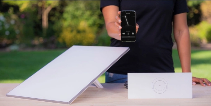 Một người dùng bên cạnh bộ thiết bị phần cứng thu phát Internet vệ tinh. Ảnh: Starlink