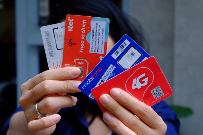 Một người dùng đang cầm trong tay nhiều thẻ SIM di động. Ảnh: Trọng Đạt
