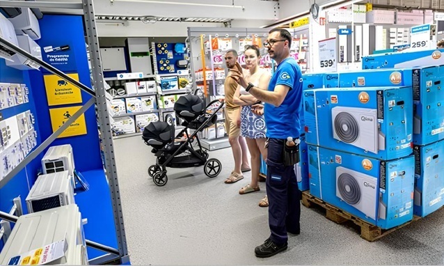Một nhân viên bán hàng đang giới thiệu hệ thống điều hòa không khí gia đình cho một cặp vợ chồng tại cửa hàng Castorama ở Bondues, Pháp, ngày 26/5/2026. Ảnh: PASCAL BONNIERE/VOIX DU NORD/MAXPPP